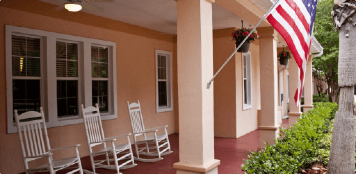 A porch with rocking chairs and an American flag, providing a comforting space.