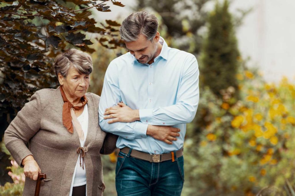 A man and woman strolling in an Alzheimer's and Dementia Care park.