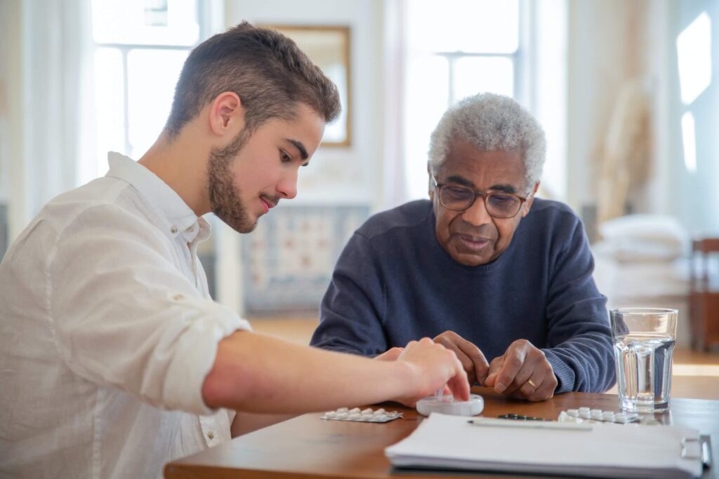 A man assists an older man with a document.