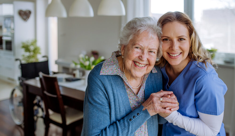 An elderly woman at an assisted living facility in Florida poses for a photo with her nurse.