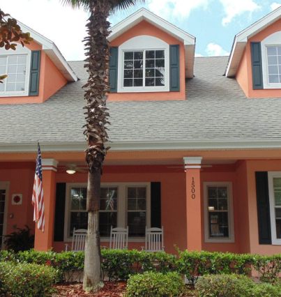 A house with a palm tree in front of it.