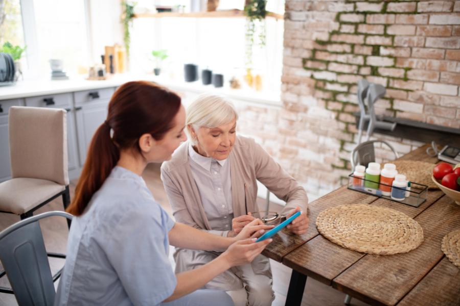 A woman in Memory care glances at a tablet.