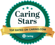 A circular badge labeled "Caring Stars," with "Top Rated in Assisted Living on Caring.com" elegantly written on a gold ribbon across it.