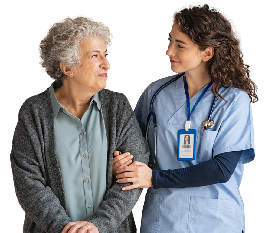 A nurse in scrubs with a stethoscope supports and smiles at an older woman in an assisted living setting. The nurse is wearing an ID badge, and both appear engaged in friendly conversation.